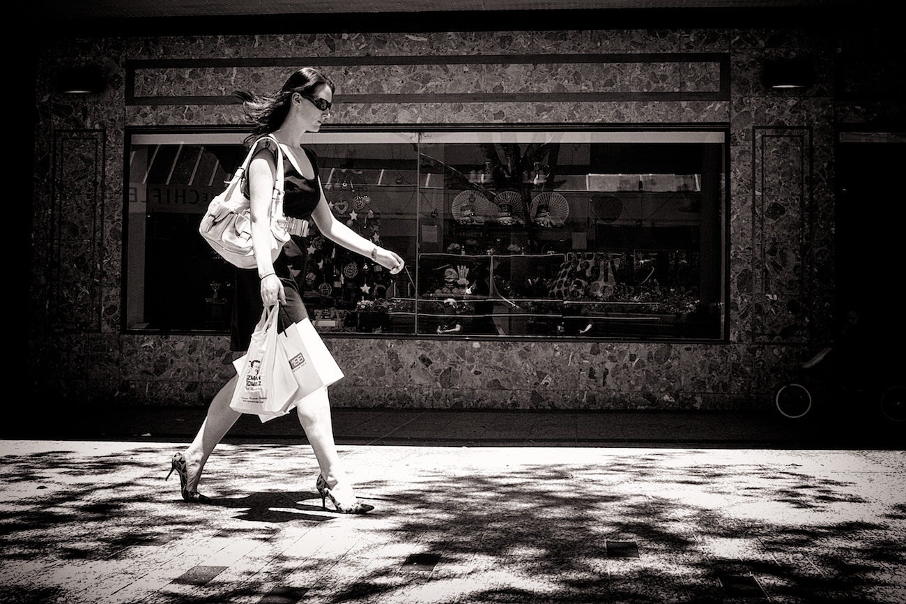 Every high style shopping street in the world seems to looks the same. A cosmopolitan woman walks down Queen St. in Brisbane with Christmas displays in the background.