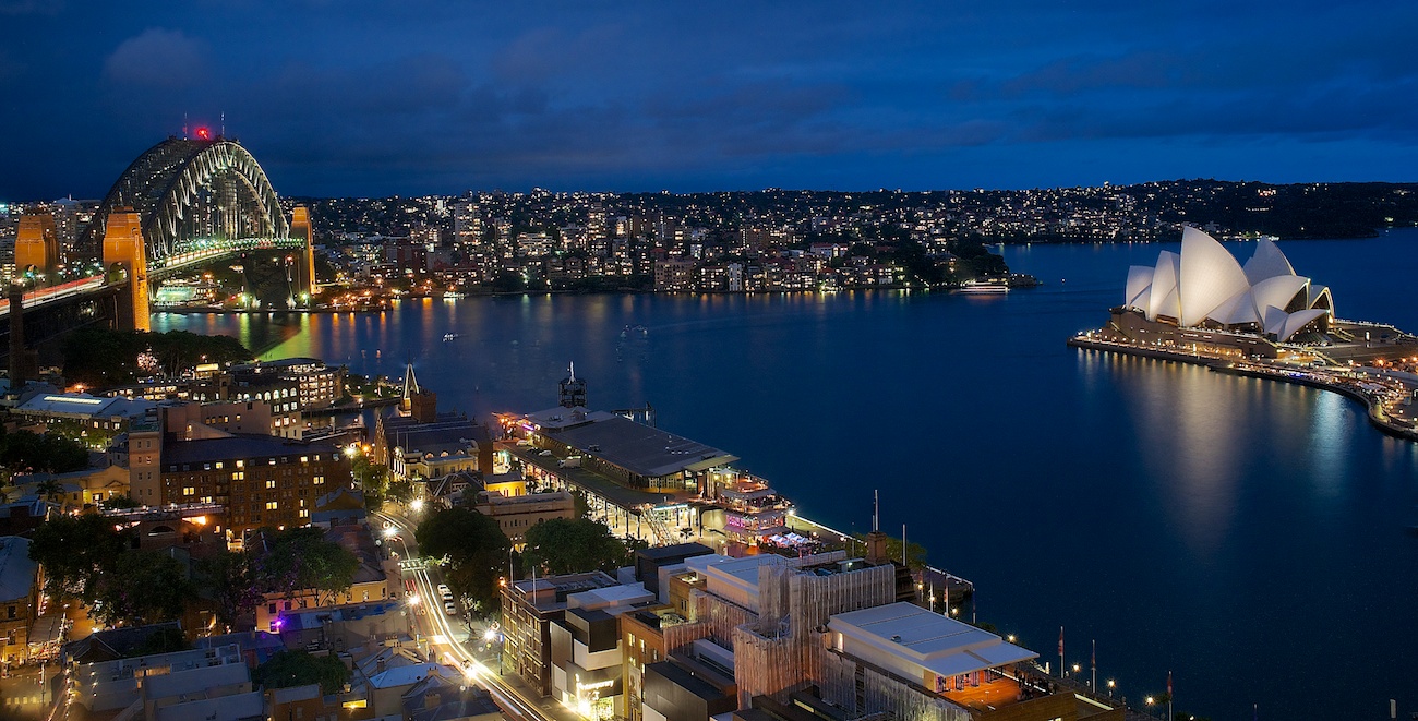 Sydney harbour at night with Opera House and Harbour Bridge lit up with lights